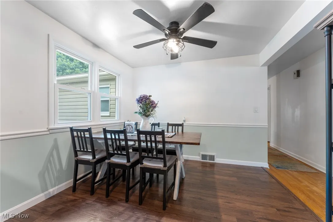 Dining space with wood finished floors and ceiling fan