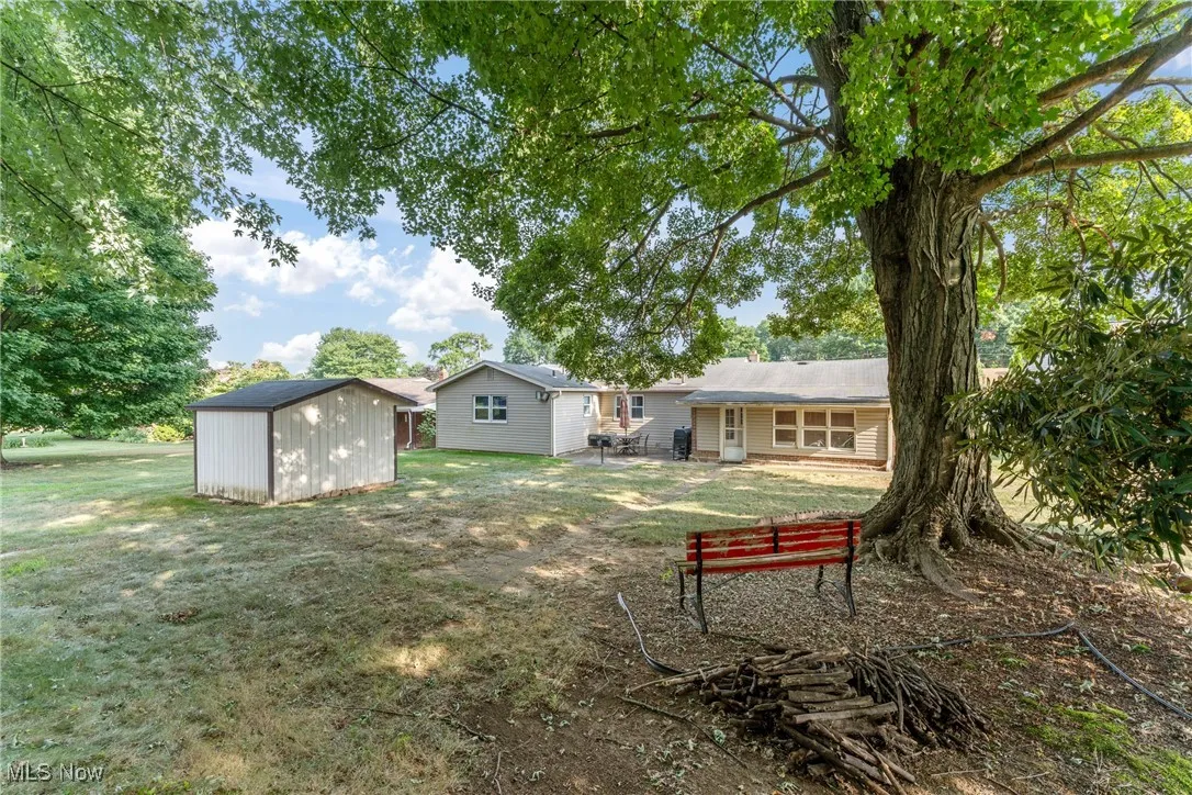 View of green lawn featuring a storage shed