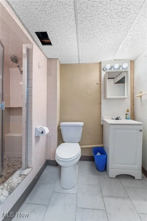 Full bathroom featuring a stall shower, vanity, and marble finish floors