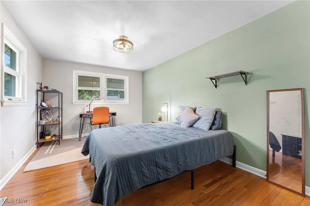 Bedroom with wood finished floors and baseboards
