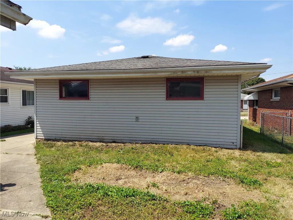 Rear view of house featuring a shingled roof