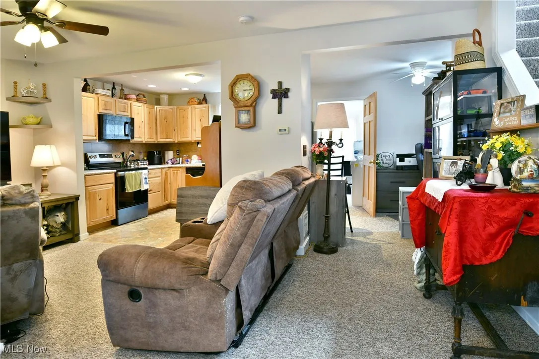 Living room featuring a ceiling fan and light colored carpet