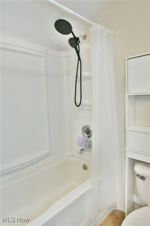 Full bath featuring shower / bath combo and toilet