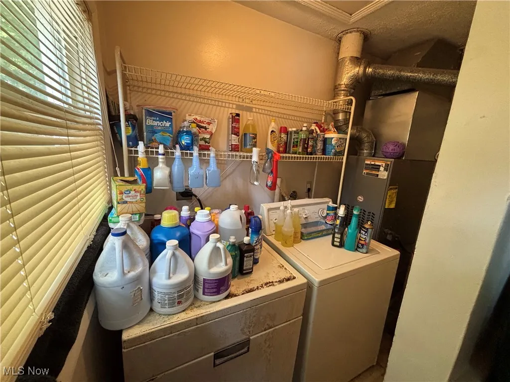 Washroom featuring washing machine and clothes dryer and heating unit