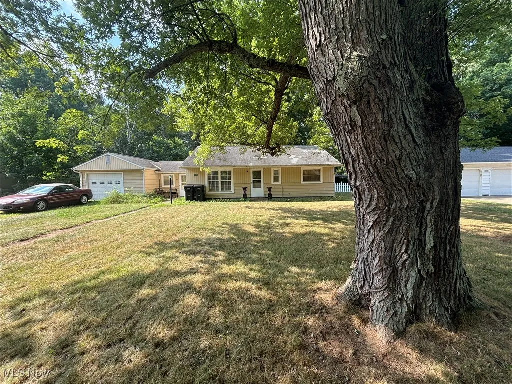 Single story home with a garage and a front yard