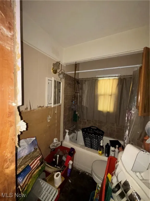 Full bath with toilet and shower / bathtub combination with curtain