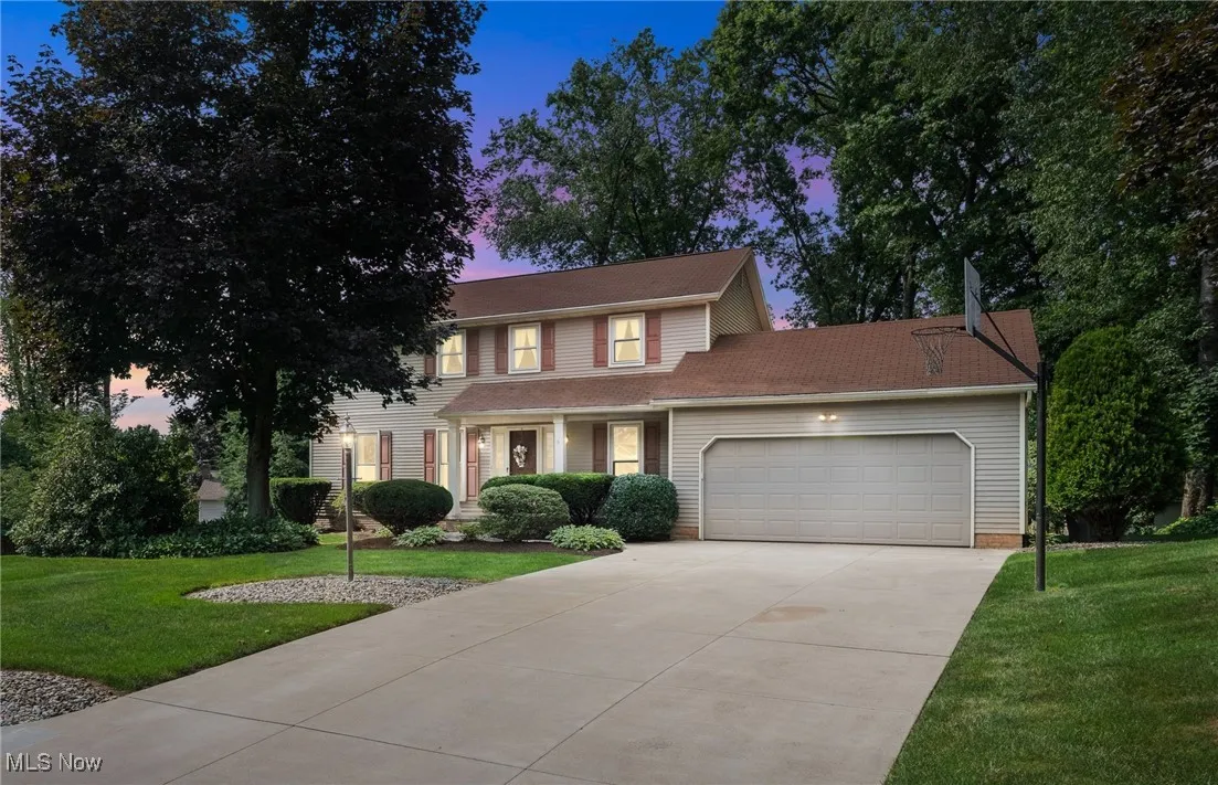 View of front of home with an attached garage, a front yard, and concrete driveway
