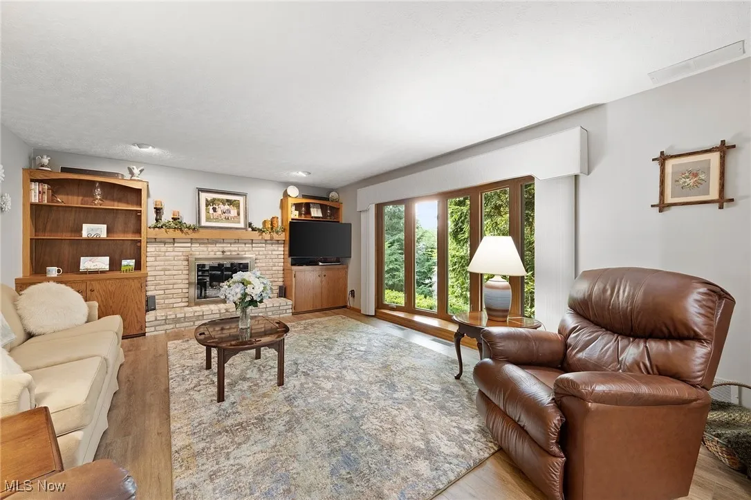 Living area featuring light wood-style floors and a brick fireplace
