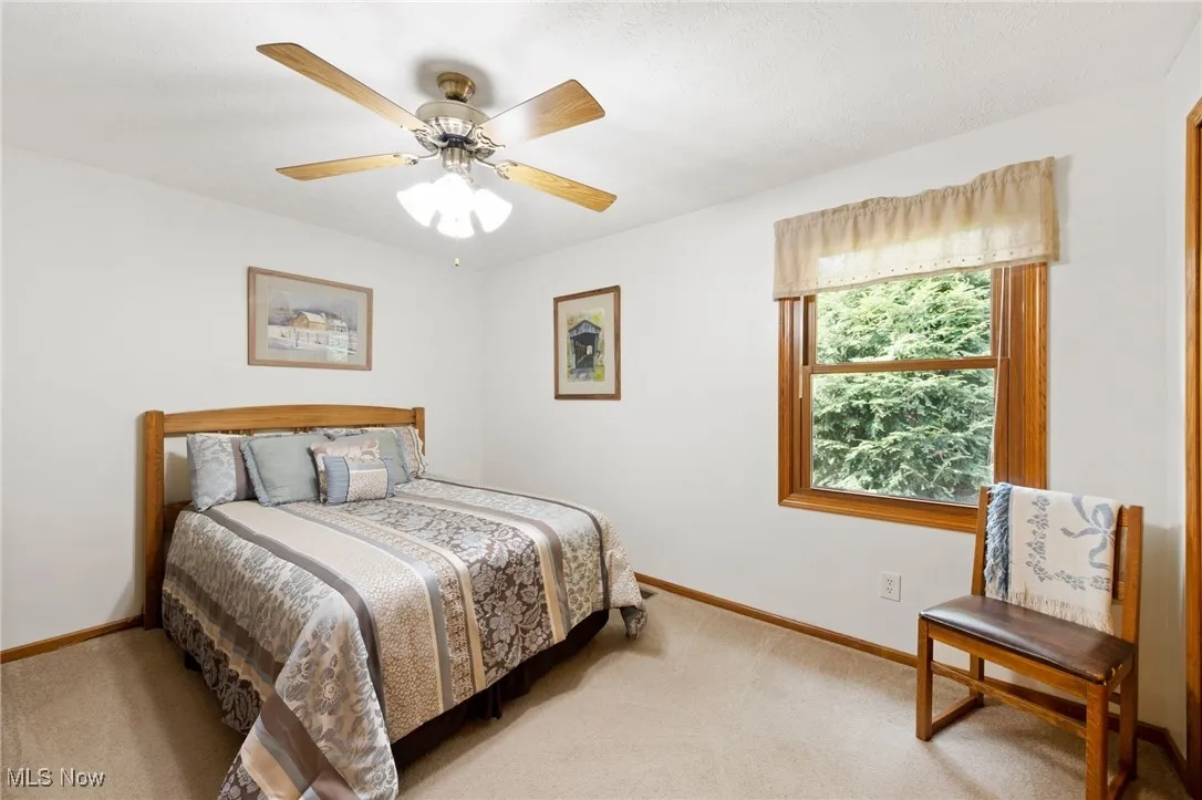 Bedroom with light colored carpet and ceiling fan