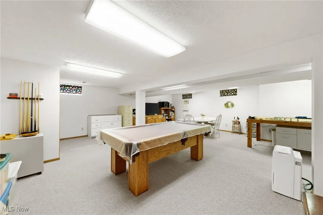 Playroom featuring light colored carpet, billiards table, and a textured ceiling