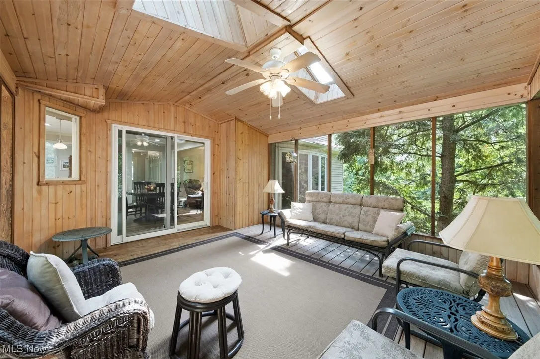Sunroom with a skylight, vaulted ceiling, ceiling fan, and an outdoor hangout area