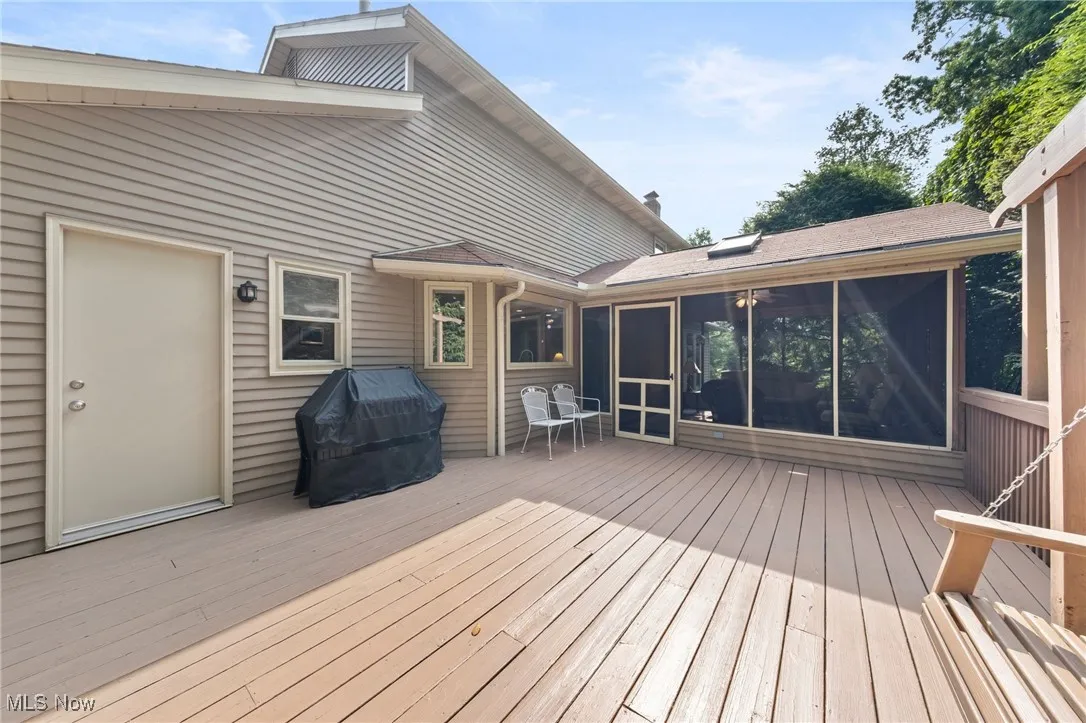 Deck featuring a sunroom and a grill