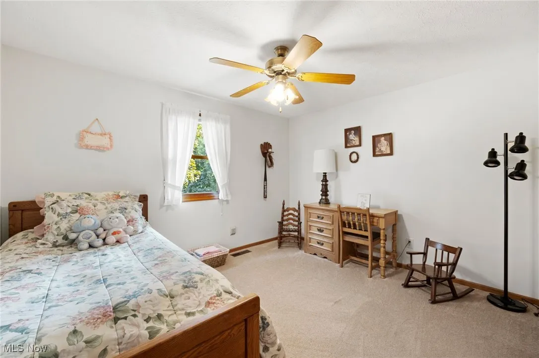 Bedroom featuring light carpet and a ceiling fan