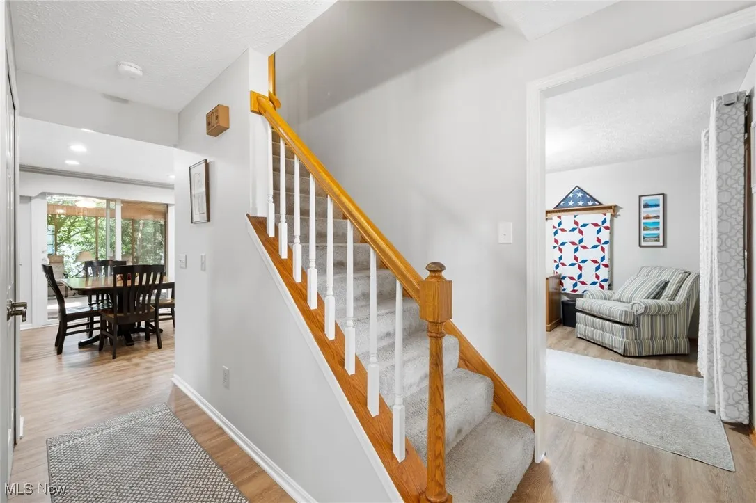 Stairway featuring wood finished floors and a textured ceiling