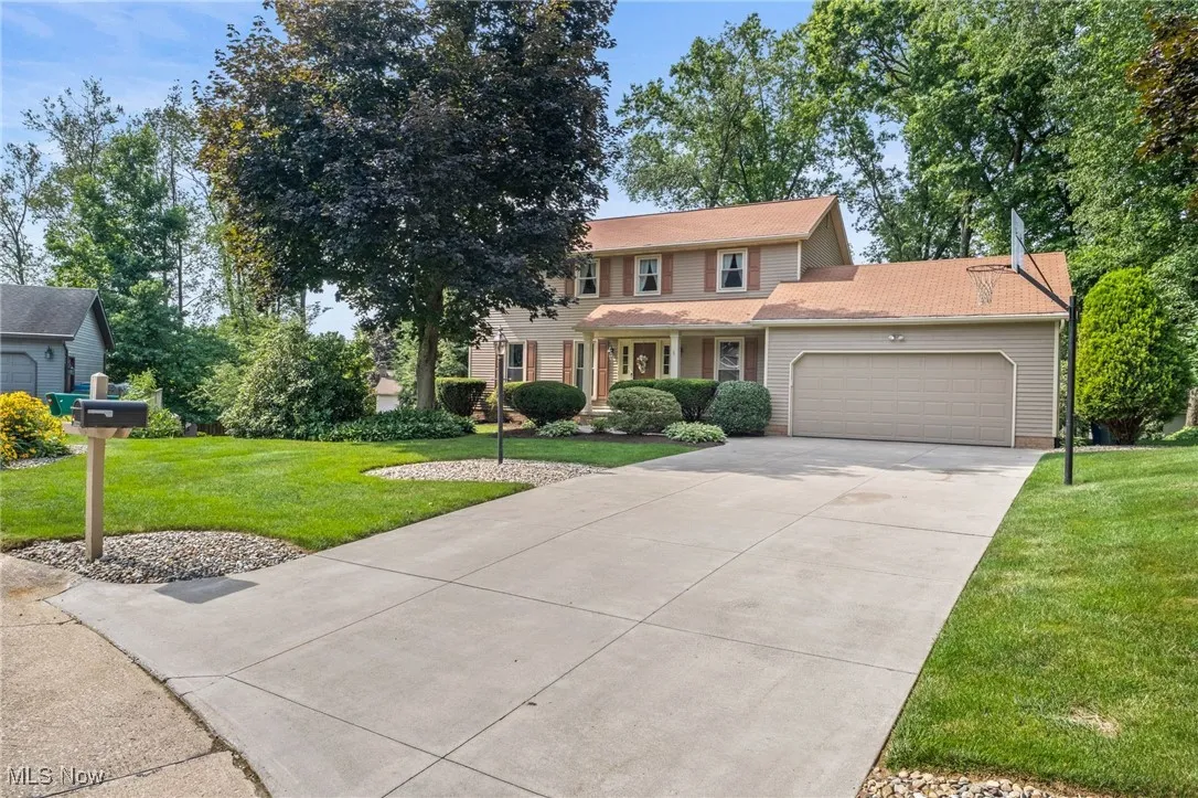 View of front of house featuring a garage, a front lawn, and driveway
