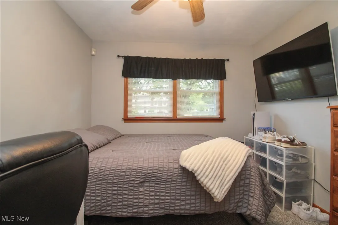 Bedroom with a ceiling fan and carpet flooring