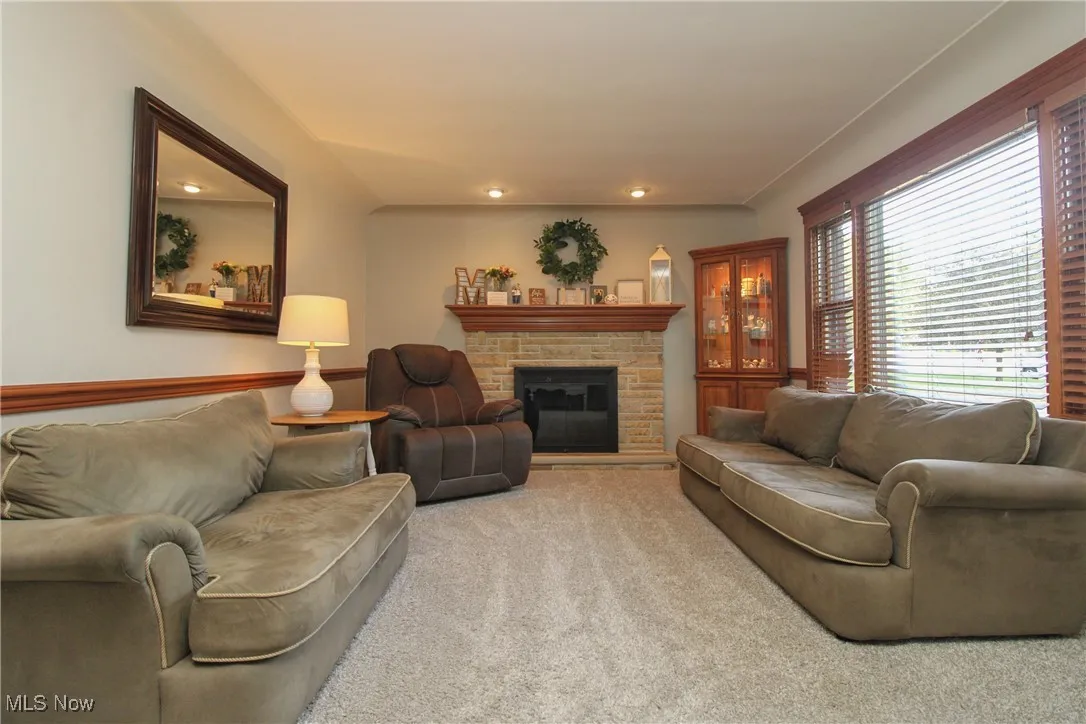 Living room featuring a fireplace, carpet flooring, and recessed lighting