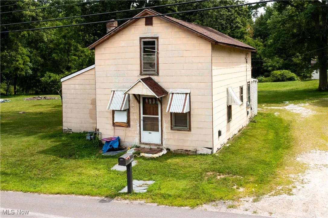 View of front facade featuring a front yard and a chimney