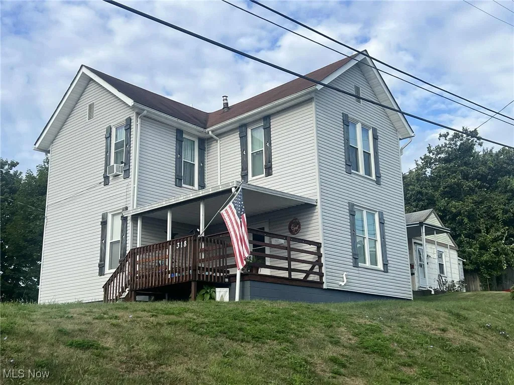 View of front of house with a front lawn and a deck