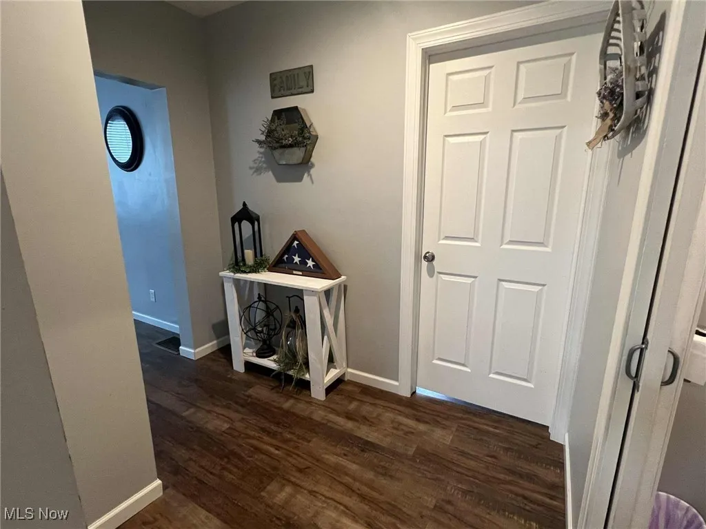 Corridor with baseboards and dark wood-style flooring