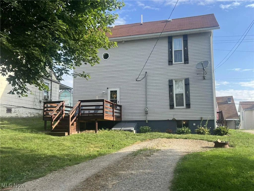 Rear view of property with a deck and a lawn