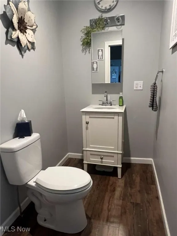 Half bathroom featuring wood finished floors and vanity