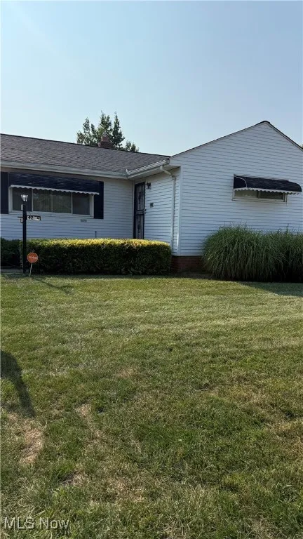 Ranch-style home featuring a front lawn and a chimney