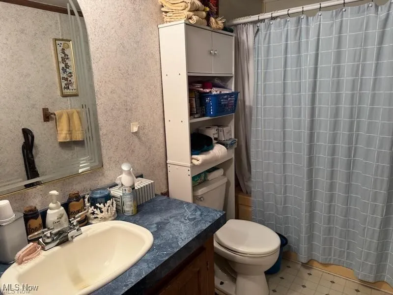 Full bathroom featuring vanity, a shower with curtain, and tile patterned floors