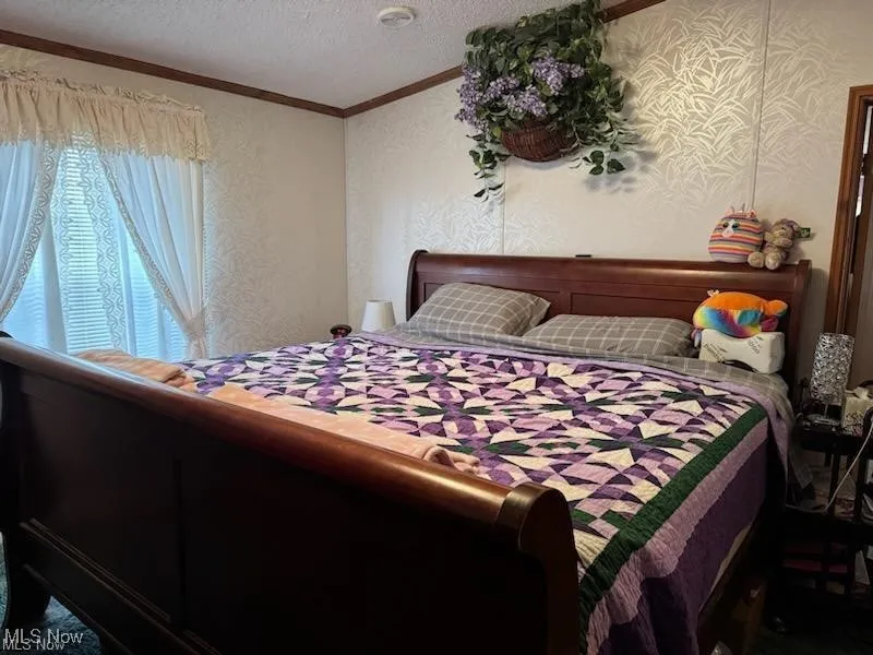 Bedroom with a textured ceiling and ornamental molding