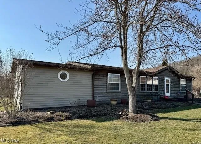 View of property exterior with a yard
