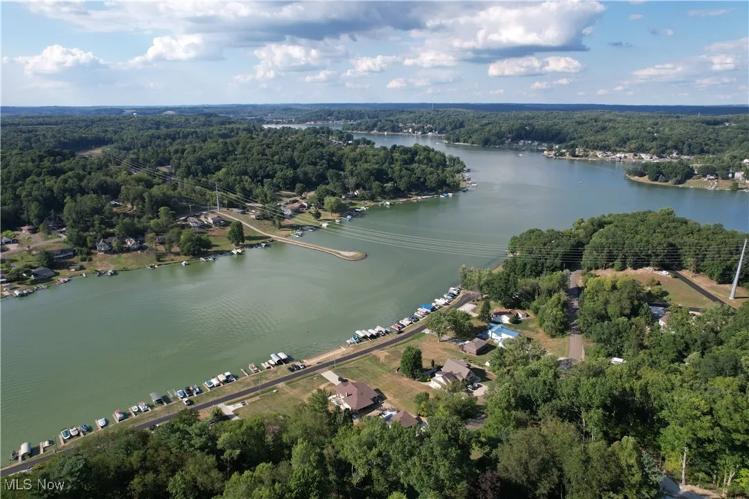 View of property location featuring a heavily wooded area and a nearby body of water