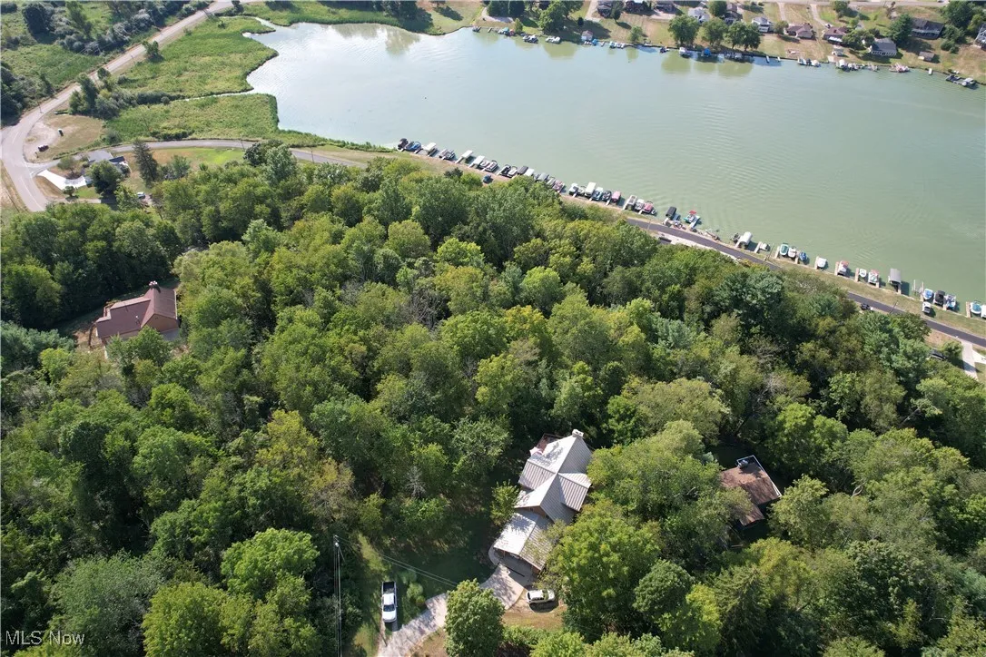 View of property location with a large body of water and a heavily wooded area