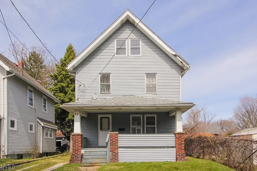 Traditional style home featuring a porch, a front yard, and roof with shingles