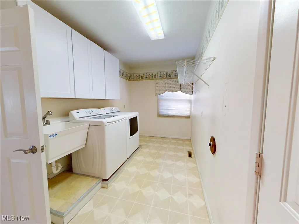 Laundry room with separate washer and dryer and cabinet space