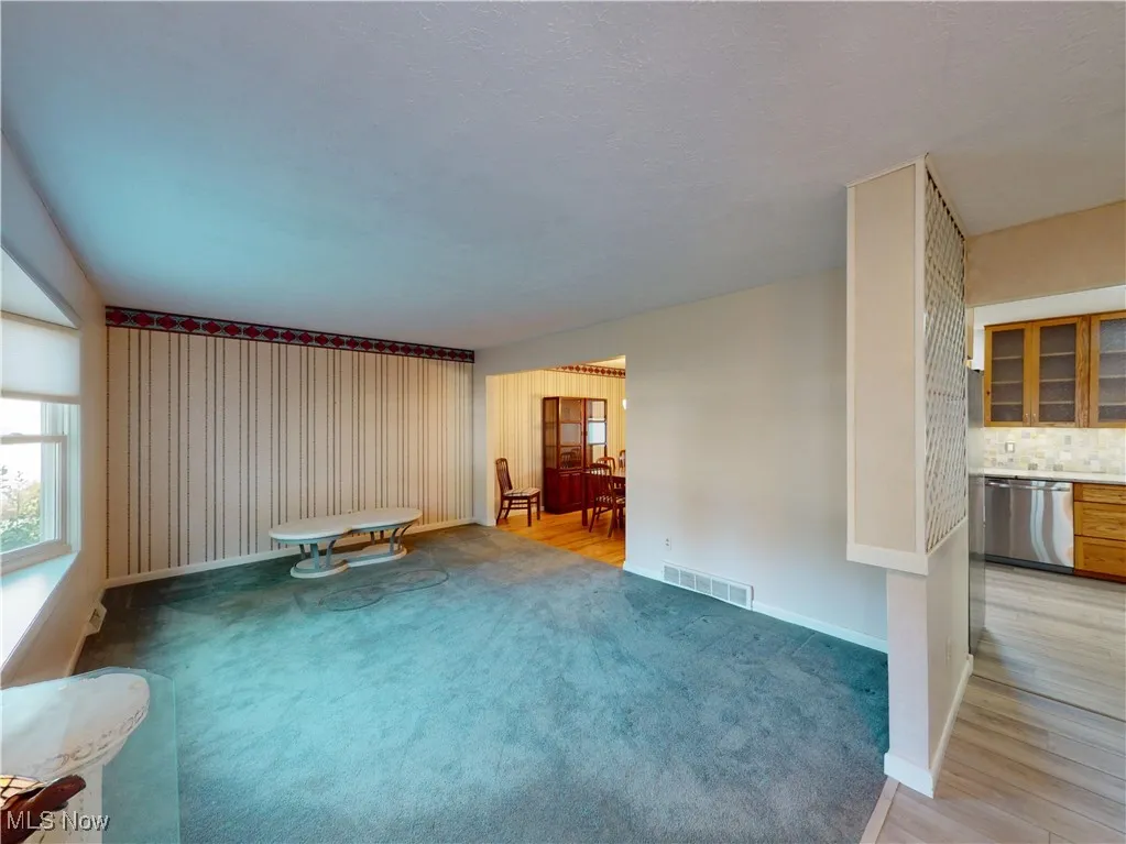 Unfurnished living room featuring light colored carpet and light wood finished floors