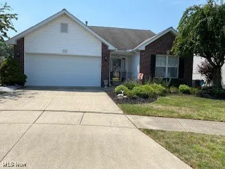 Ranch-style house featuring an attached garage, driveway, and brick siding