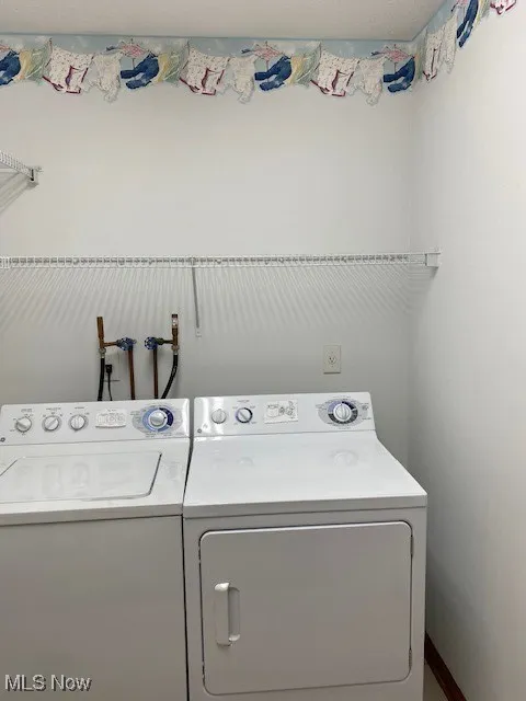 Laundry room featuring separate washer and dryer and baseboards