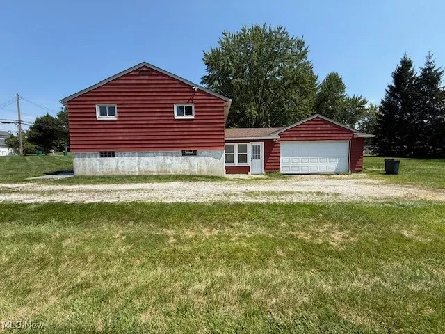 View of front facade with a front lawn, an attached garage, and driveway