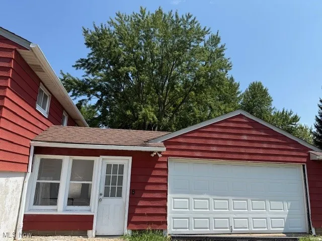 View of front of property with a garage and an outdoor structure