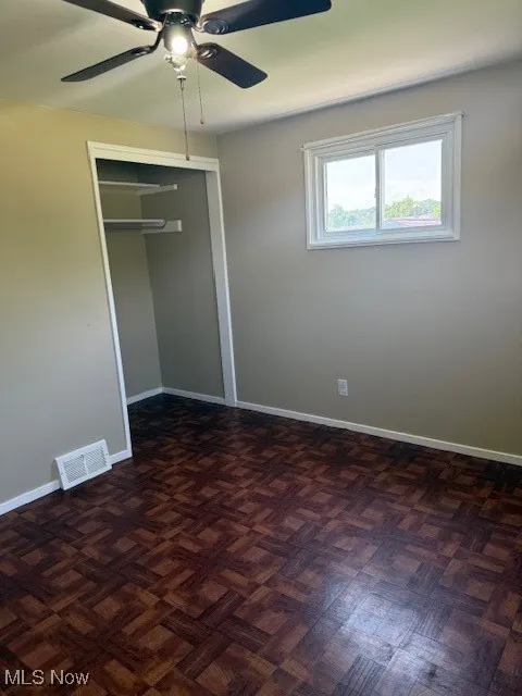 Unfurnished bedroom with a closet and ceiling fan