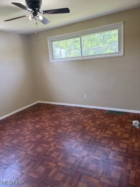 Unfurnished room with baseboards and ceiling fan