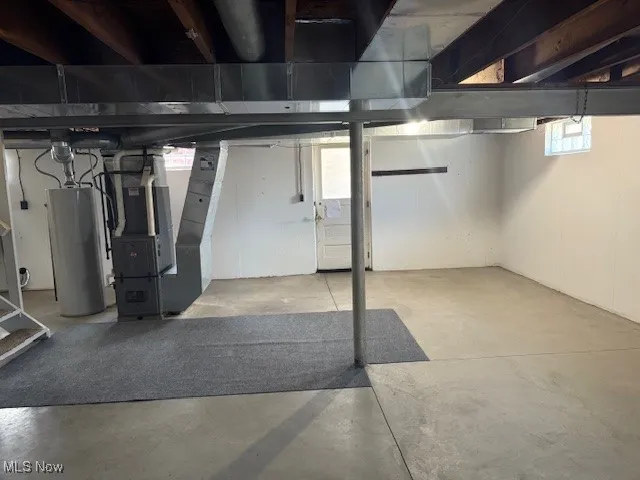 Basement featuring heating unit and water heater