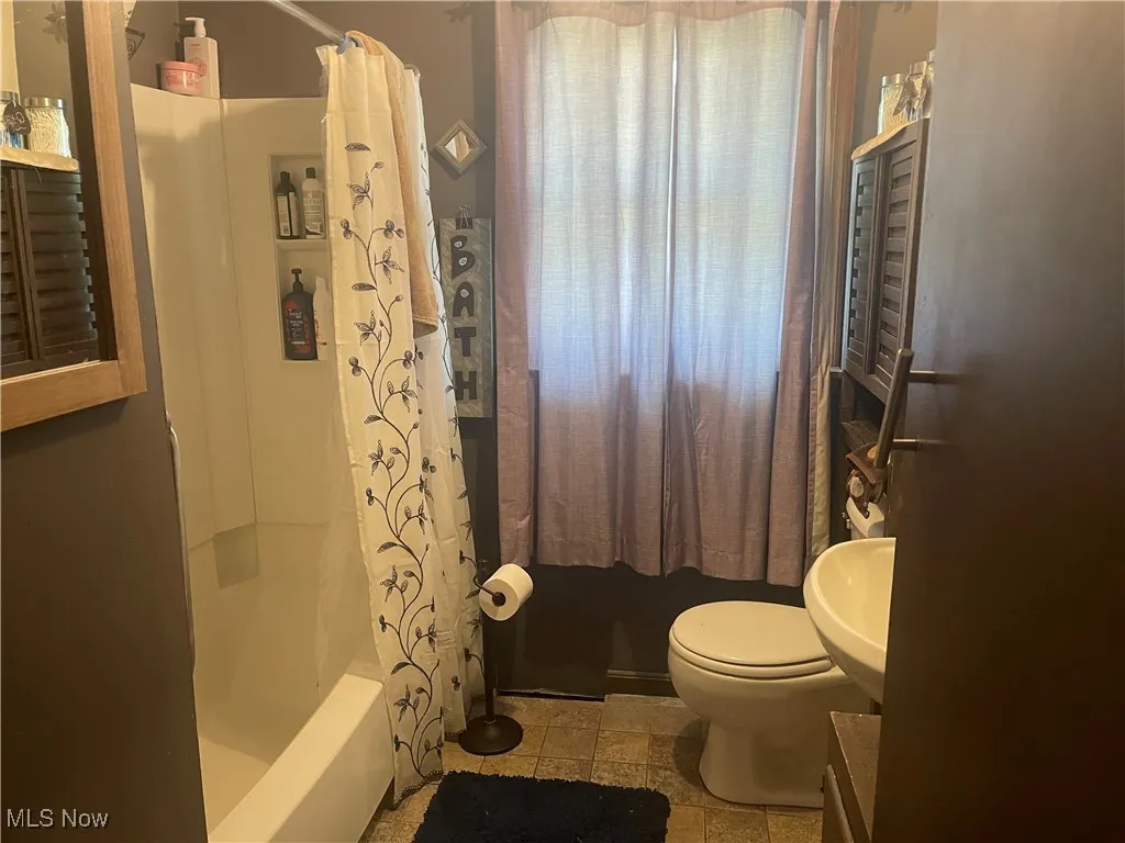 Full bath with shower / bath combo with shower curtain and vanity