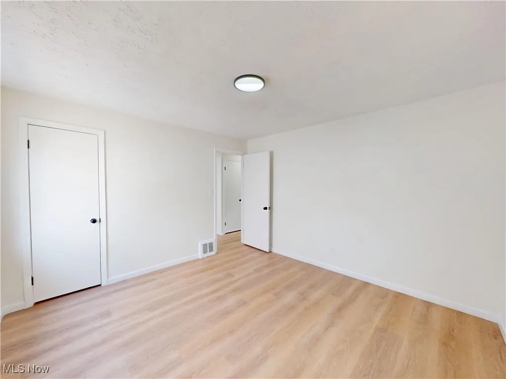 Spare room with light wood-style flooring and a textured ceiling