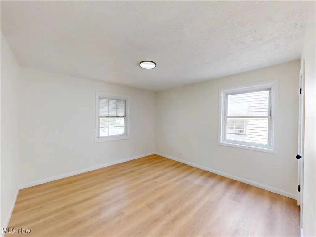 Spare room featuring light wood-style floors and a textured ceiling