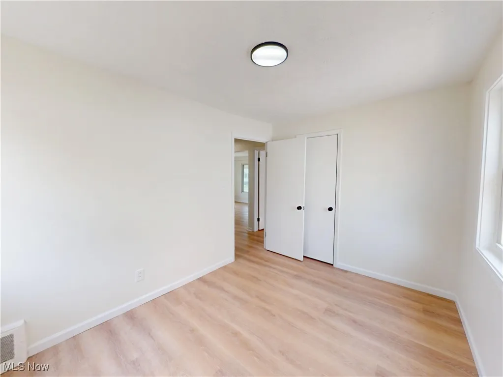 Unfurnished bedroom with light wood-type flooring and a closet