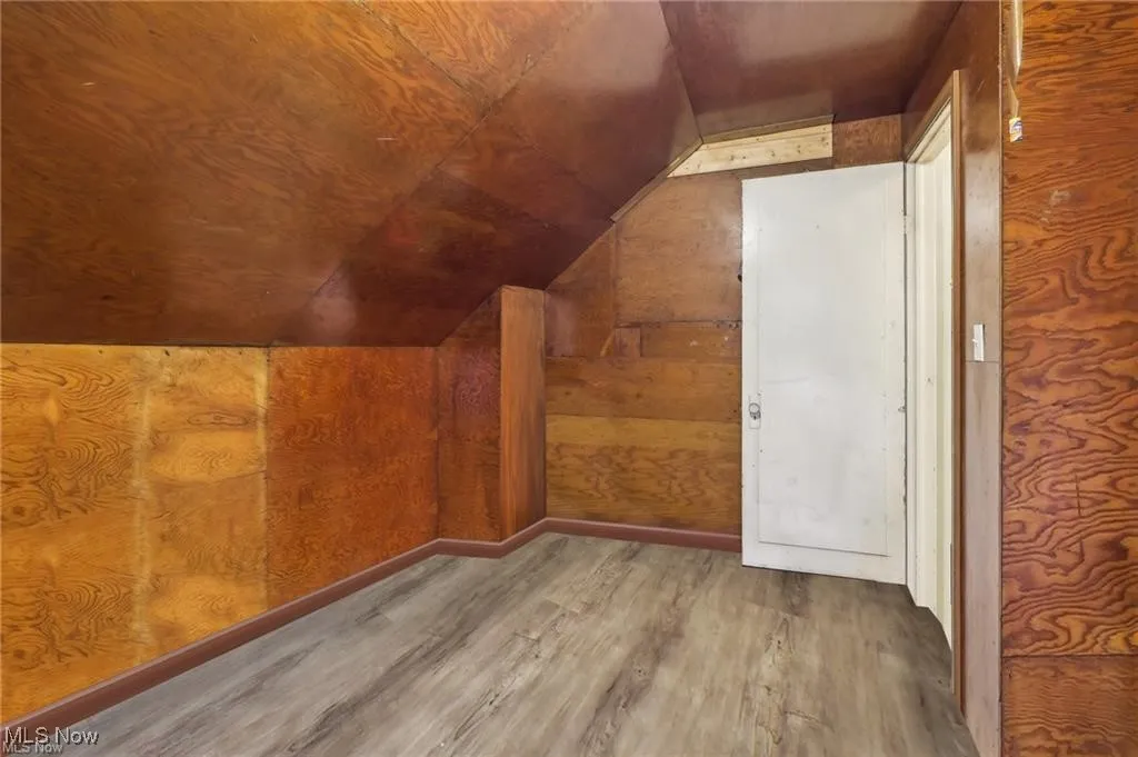 Additional living space with wood finished floors and vaulted ceiling