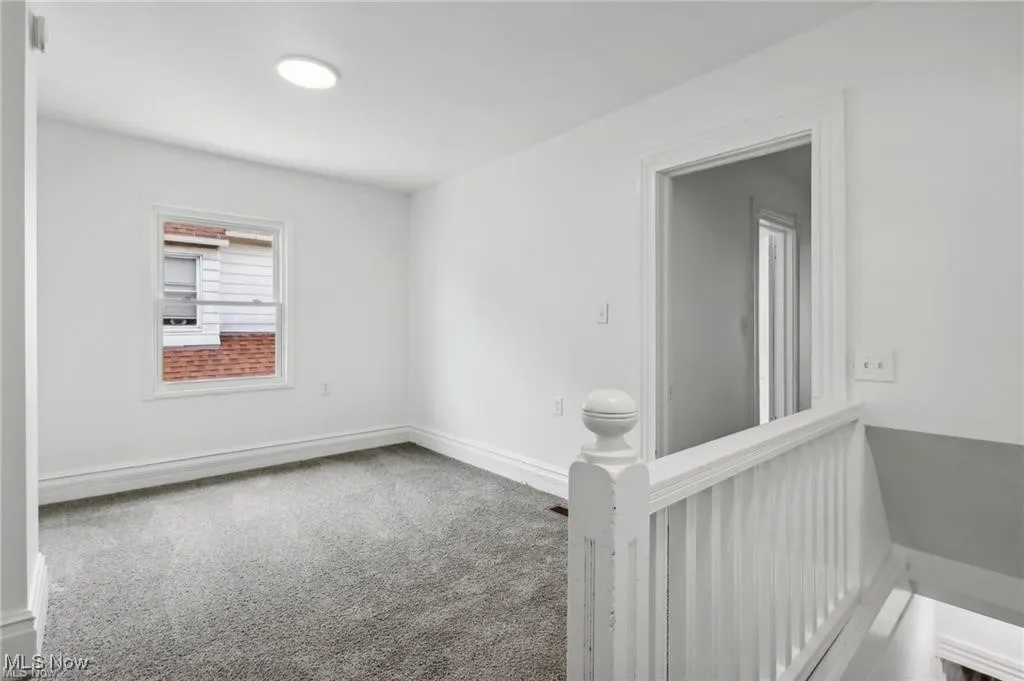 Spare room featuring carpet floors and baseboards