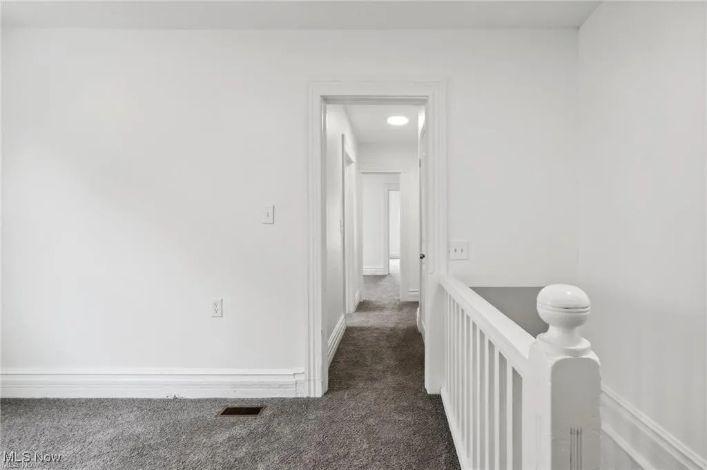 Corridor with carpet and an upstairs landing