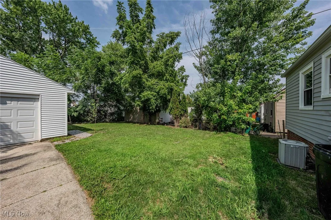View of green lawn with a garage